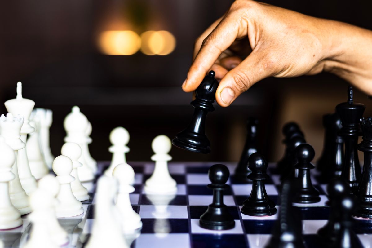 A chessboard, early in the game, with the black bishop advancing.